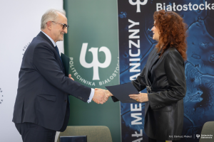 Rektor Wiesław Czołpiński i Rektorka Marta Kosior-Kazberuk ściskają dłoń po podpisaniu porozumienia.