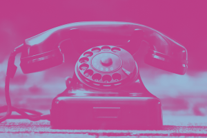 Zrastrowane na różowo zdjęcie starego aparatu telefonicznego z tarczą.