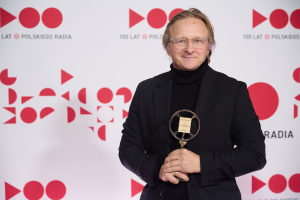 Łukasz Lewandowski trzymający statuetkę Złotego mikrofonu.