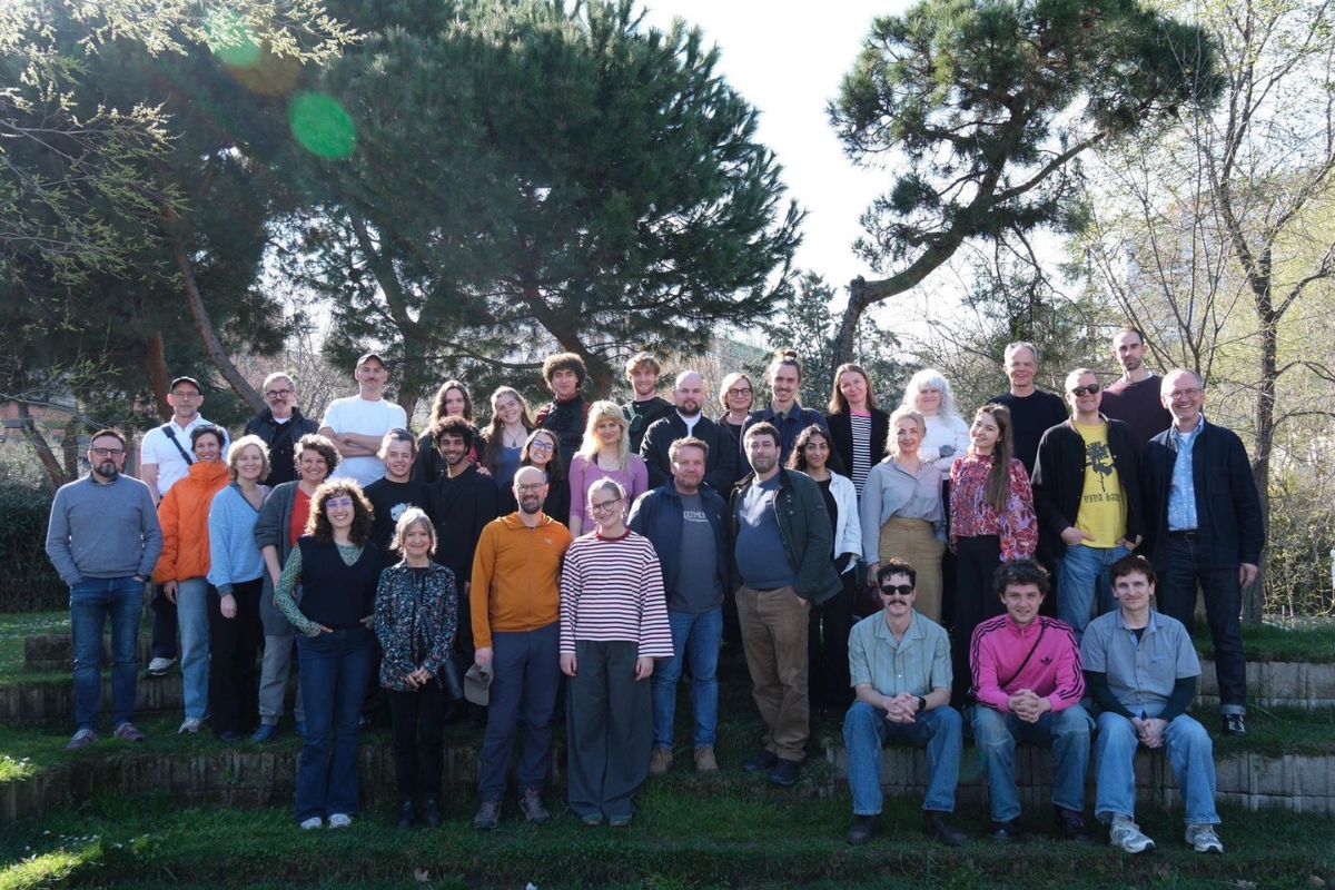 Zbiorowa fotografia uczestników zjazdu na świeżym powietrzu w otoczeniu drzew.